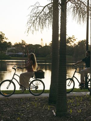 couples portrait session with natural light bike ride by park