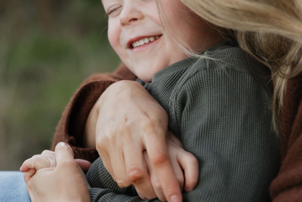 Candid close-up of shared laughter and affection in casual outdoor setting.