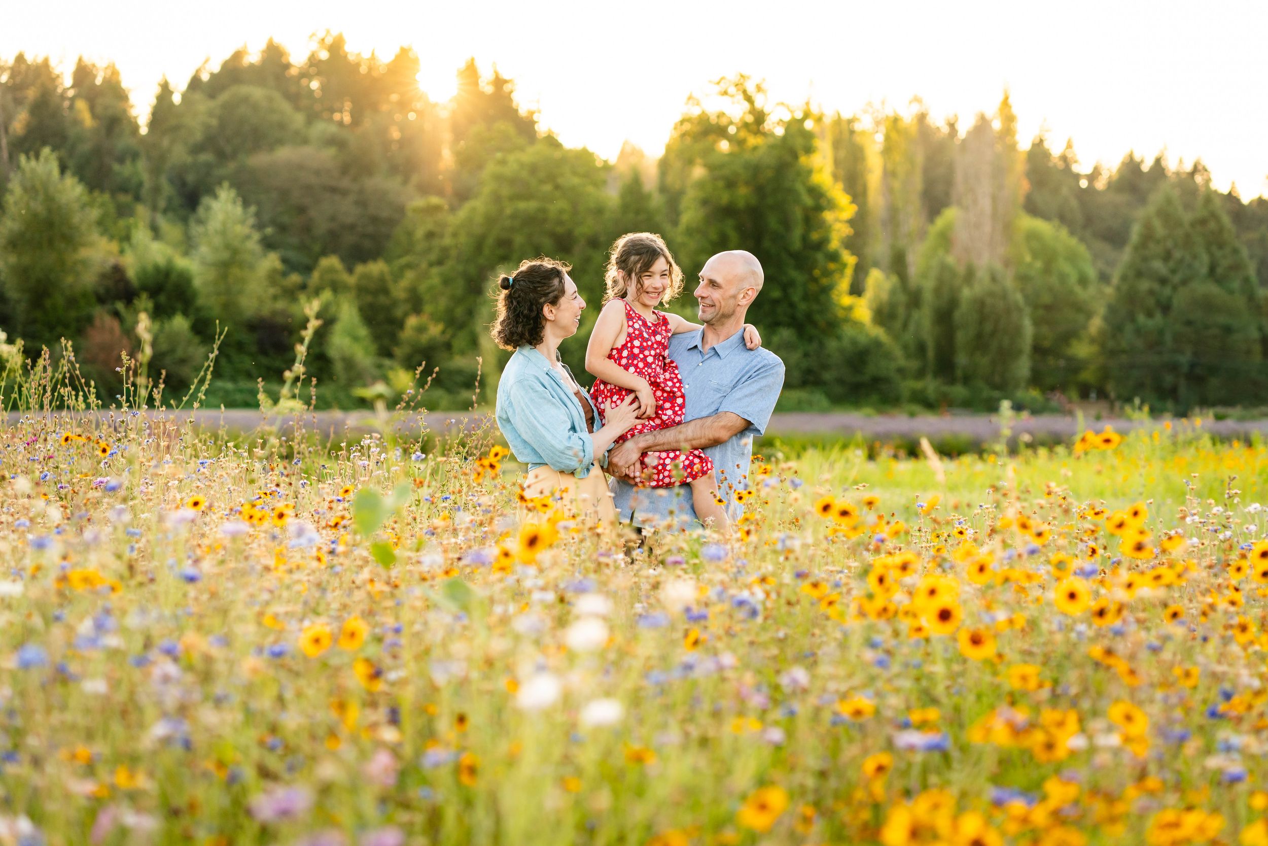 Family tickling each other in a flower field at sunset in Woodinville.