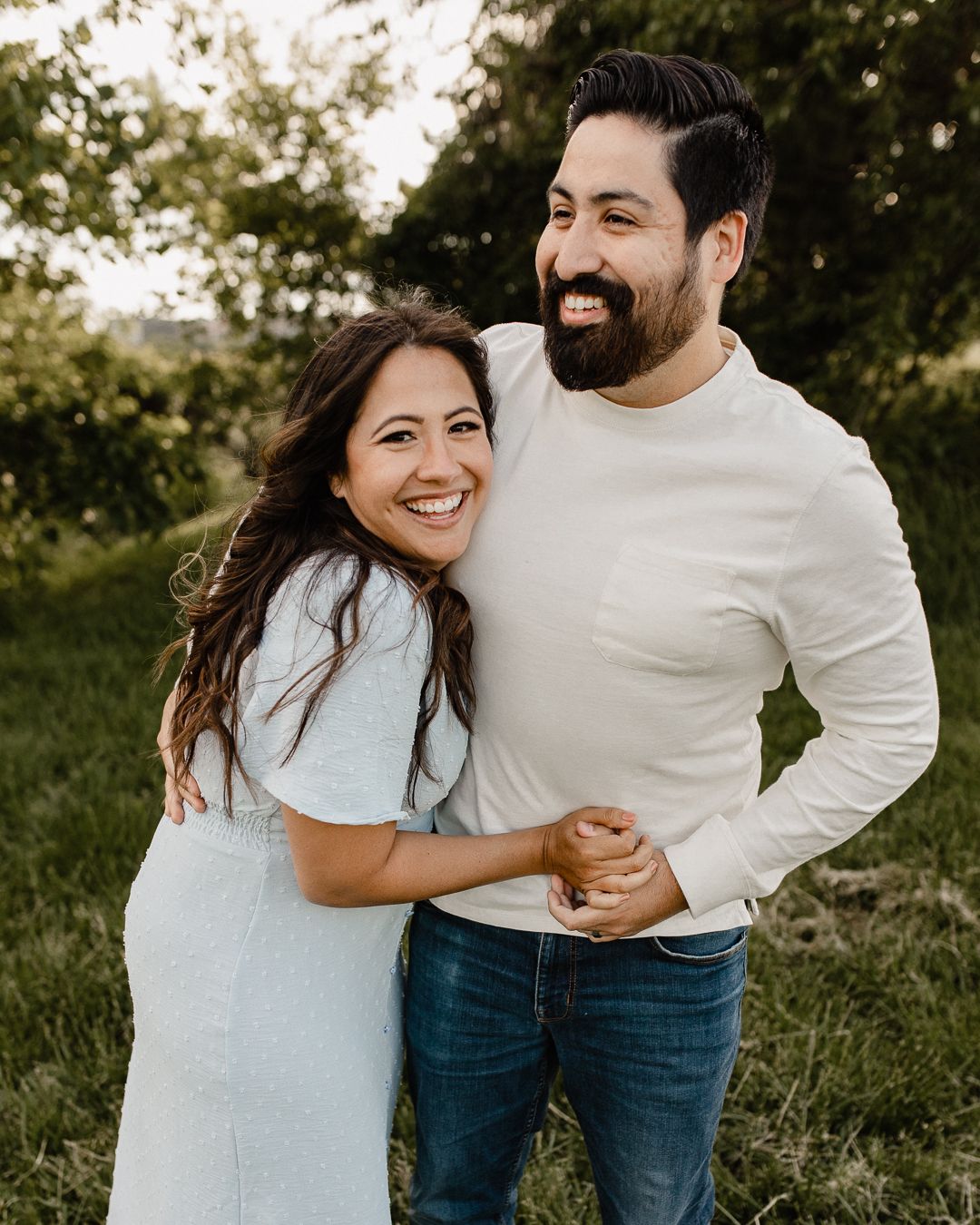 Casual engagement photoshoot in a natural outdoor setting with afternoon light.