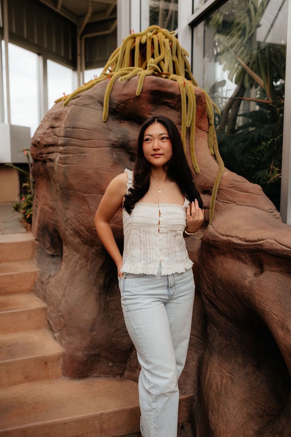 A casual portrait against a decorative rock wall structure with yellow ropes.
