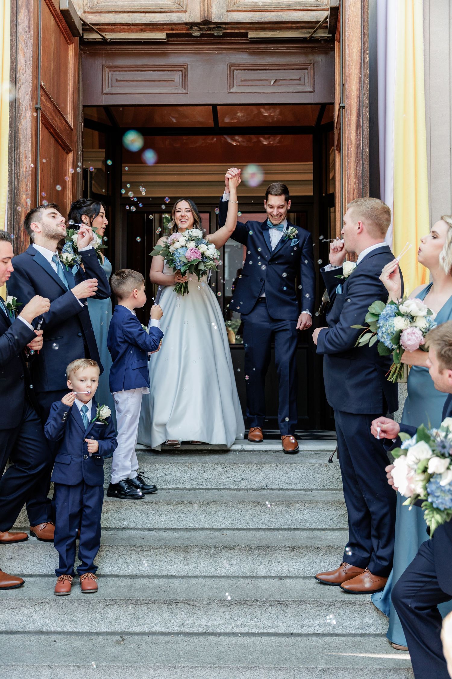 An intimate wedding portrait showing a tender moment against a floral backdrop.