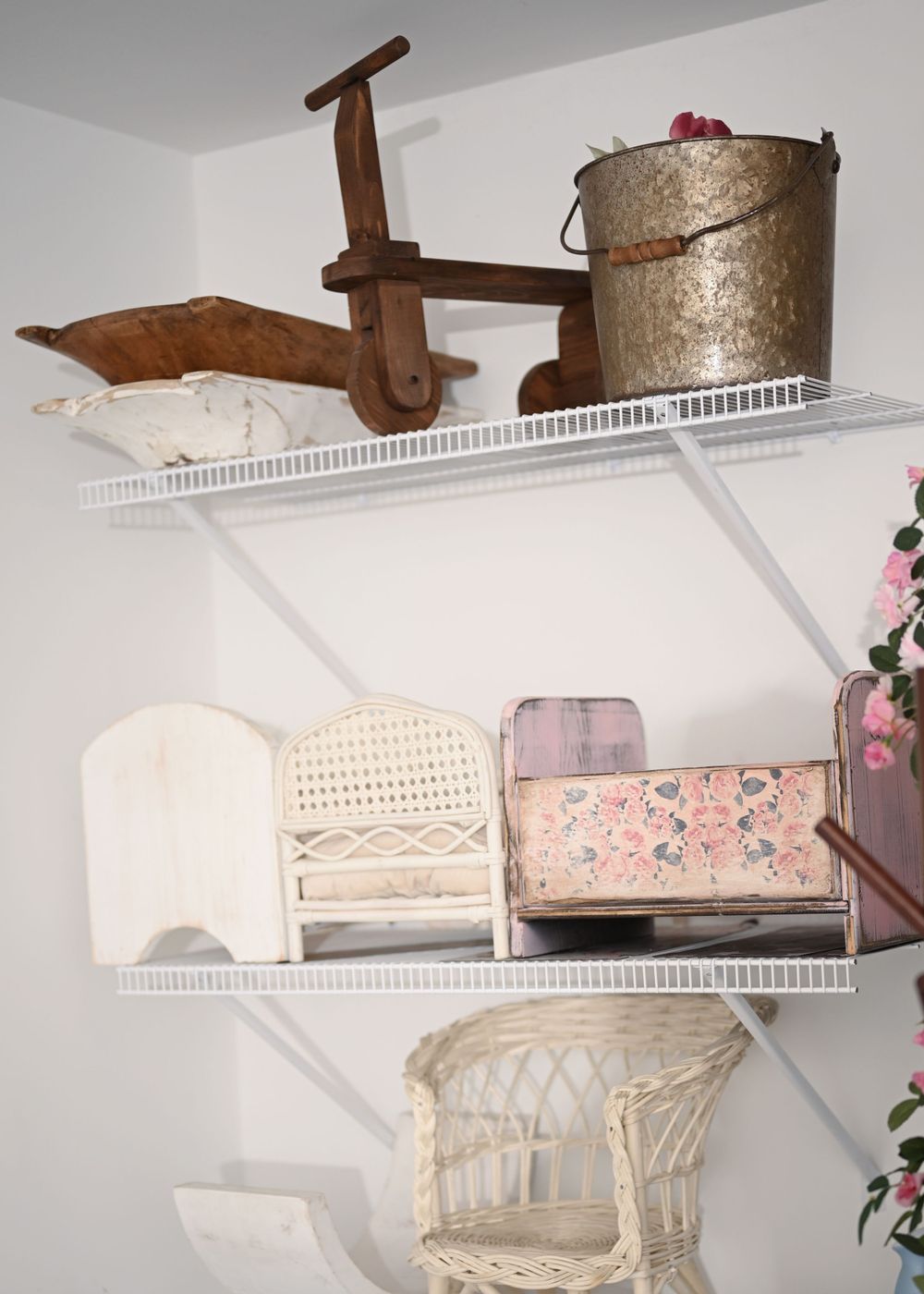 White wire shelving with vintage props and decorative storage boxes.