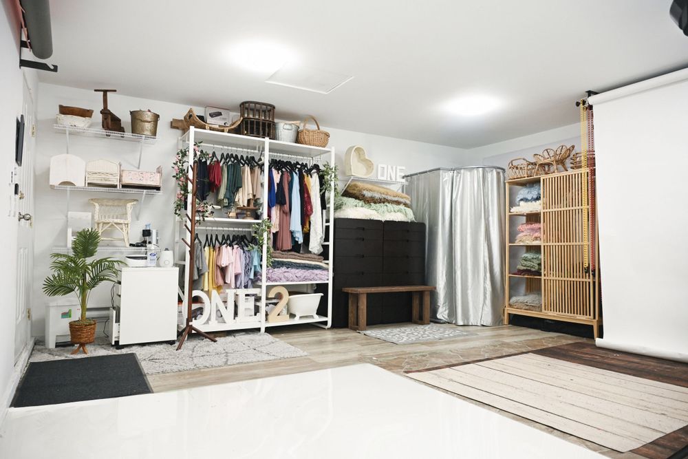 Clean white photography studio space with wood flooring and natural lighting.
