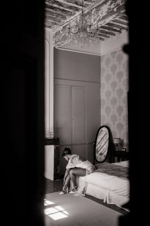 A sunlit bedroom interior with vintage furniture and exposed ceiling beams.