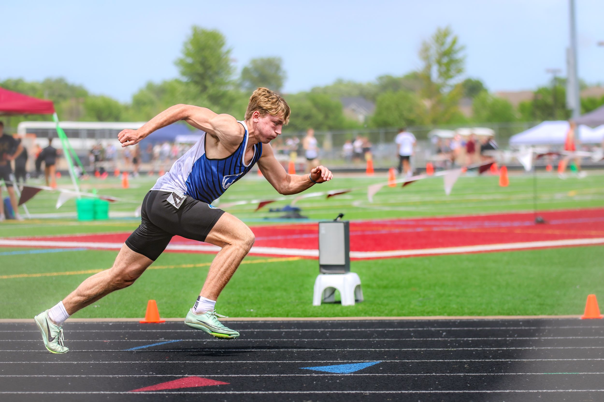 Sprinter in starting position on track during athletic competition.