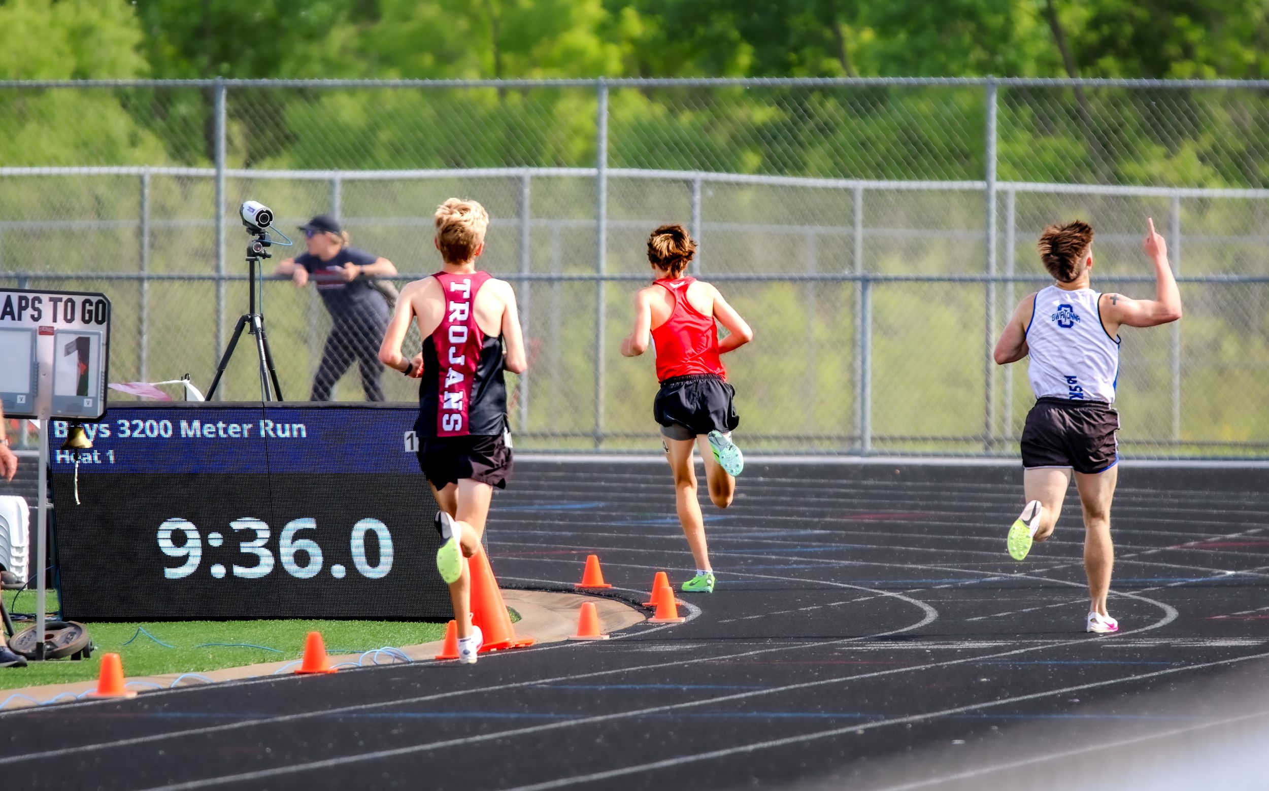 High school athletes racing on outdoor track during competition.