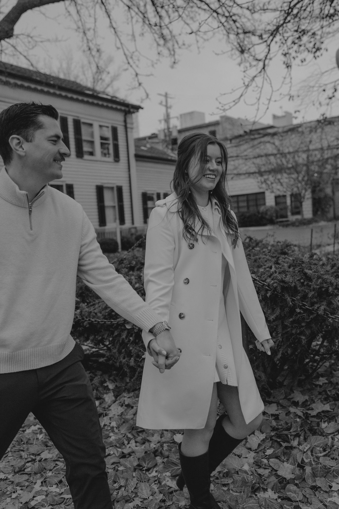 Black and white photo series of a couple holding hands and walking together in a garden setting.