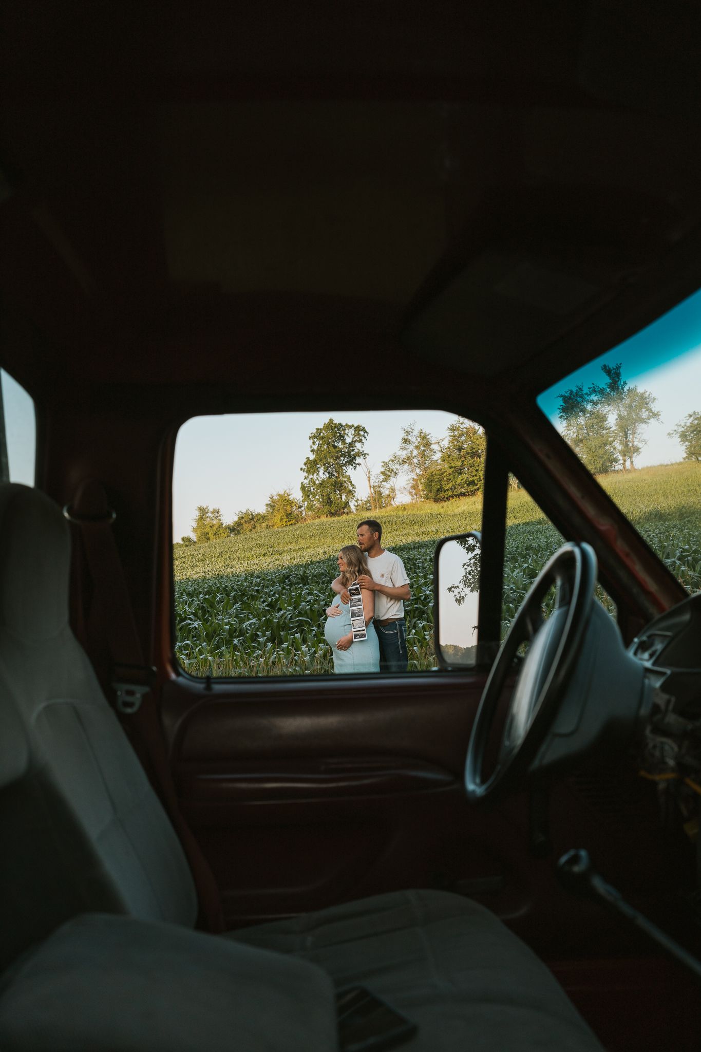 A sequence of photos taken from inside a car showing a field and trees through the window at sunset.