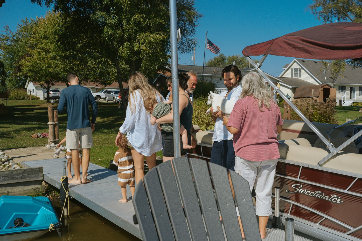 Friends and family gathering on wooden dock by the water on a sunny day in Muskegon MI