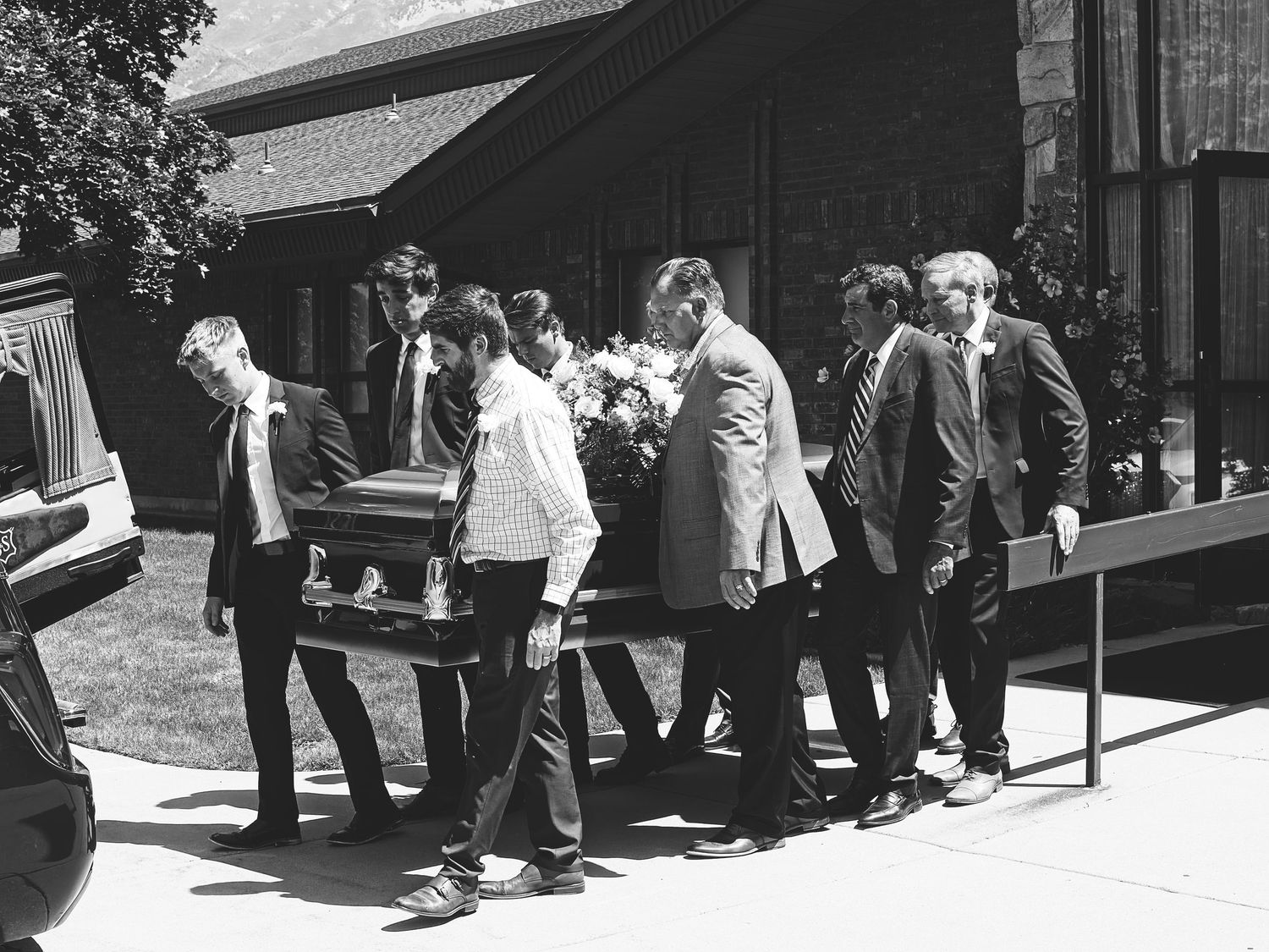 Pall bearers carry the casket to the hearse for transportation