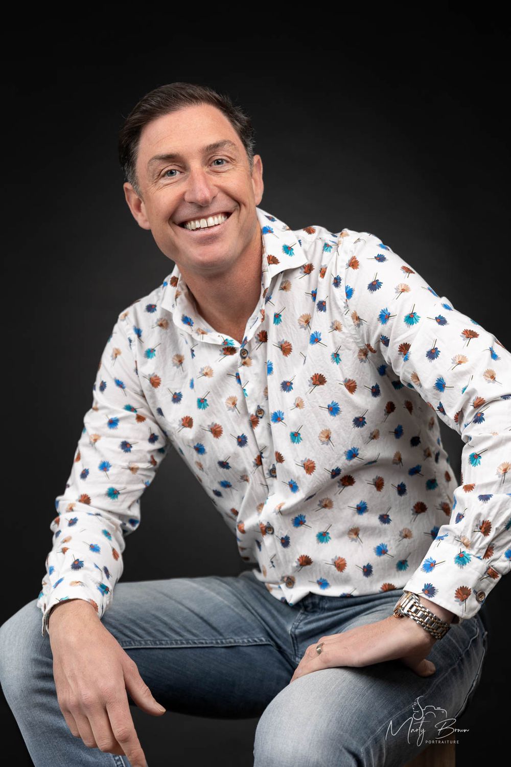 Corporate man in dress shirt sitting in studio portrait
