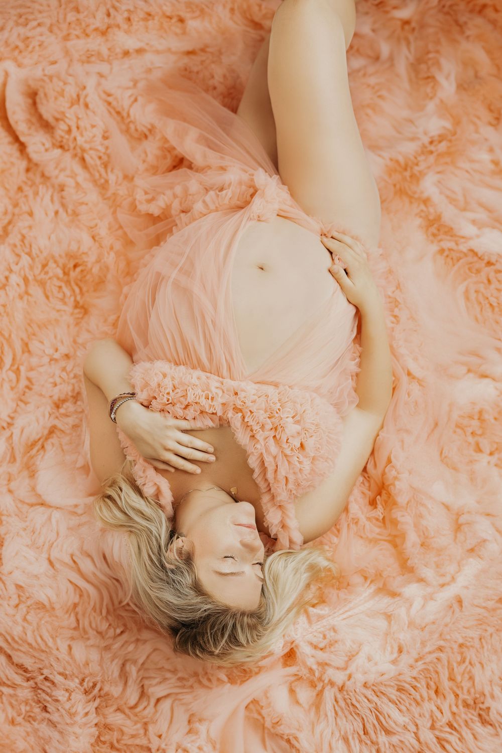 Dreamy peach-toned maternity portraits with soft, romantic lighting.