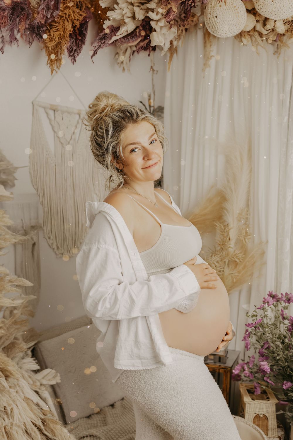 Light and airy maternity session with white ruffled dress and dried flower arrangements.