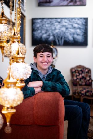Interior portrait with glowing gold chandeliers and a plush orange armchair.
