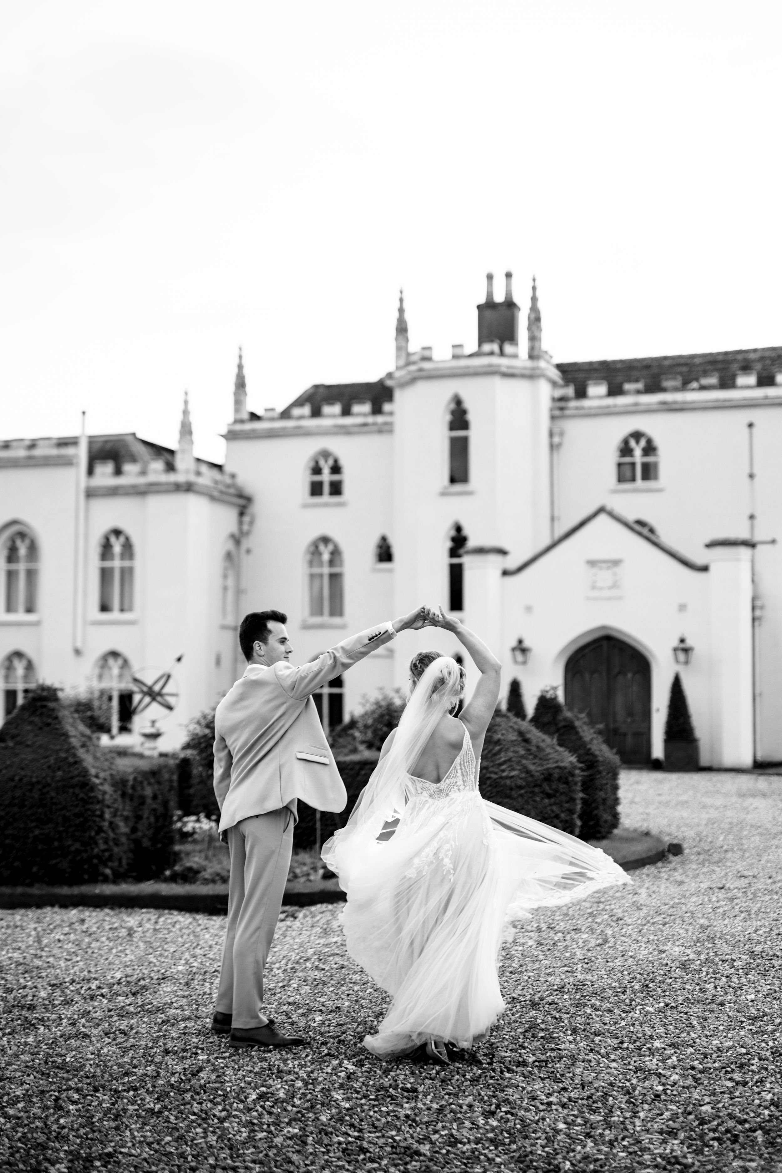 A romantic scene unfolds against a grand white Gothic revival building with elegant architecture.