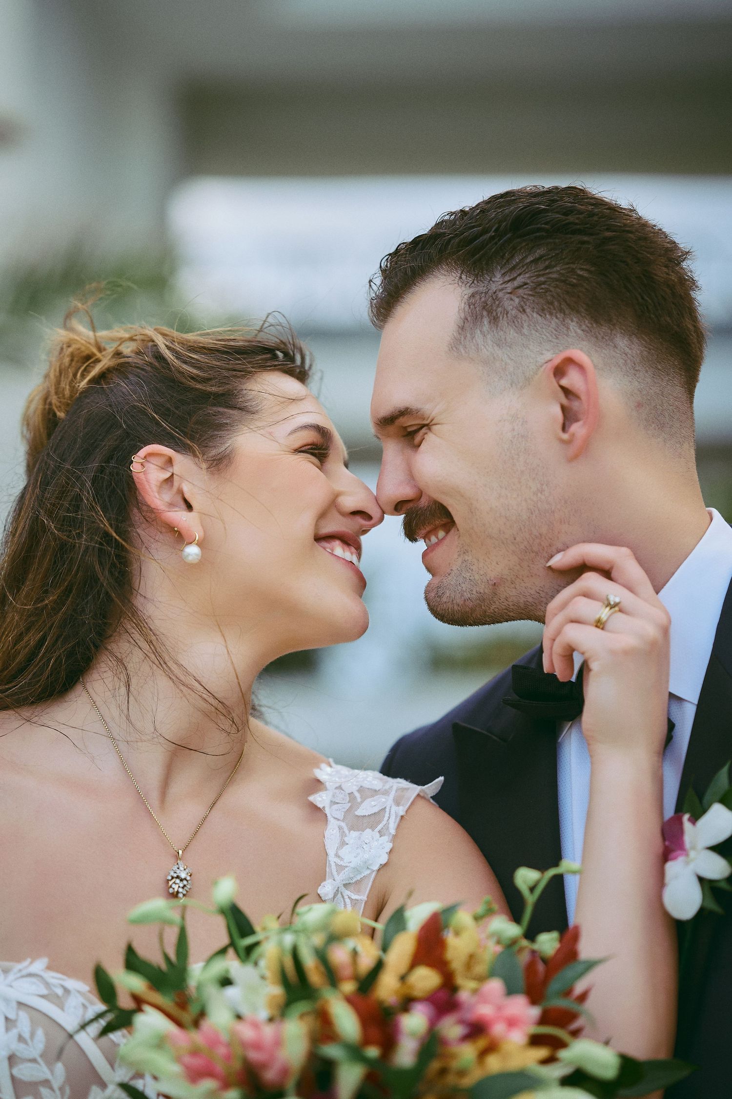 A romantic couple in wedding attire embrace on a wooden pier overlooking the ocean at sunset by Jamaica Wedding Photographer