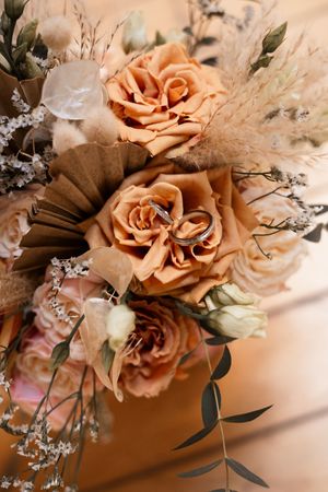 Close-up view of peach-colored roses with delicate baby's breath and eucalyptus leaves in a floral arrangement.