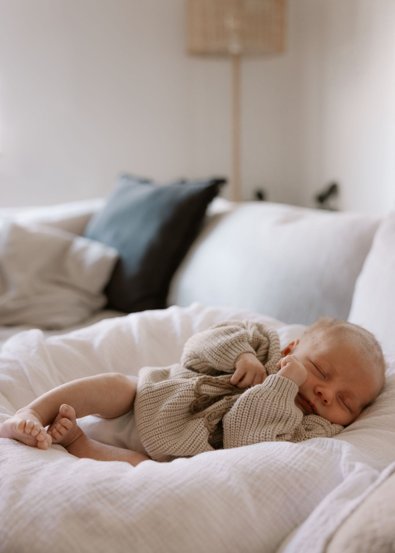 Newborn baby on a plush sheepskin rug, bathed in natural light during an in-home newborn photoshoot in Wollongong.