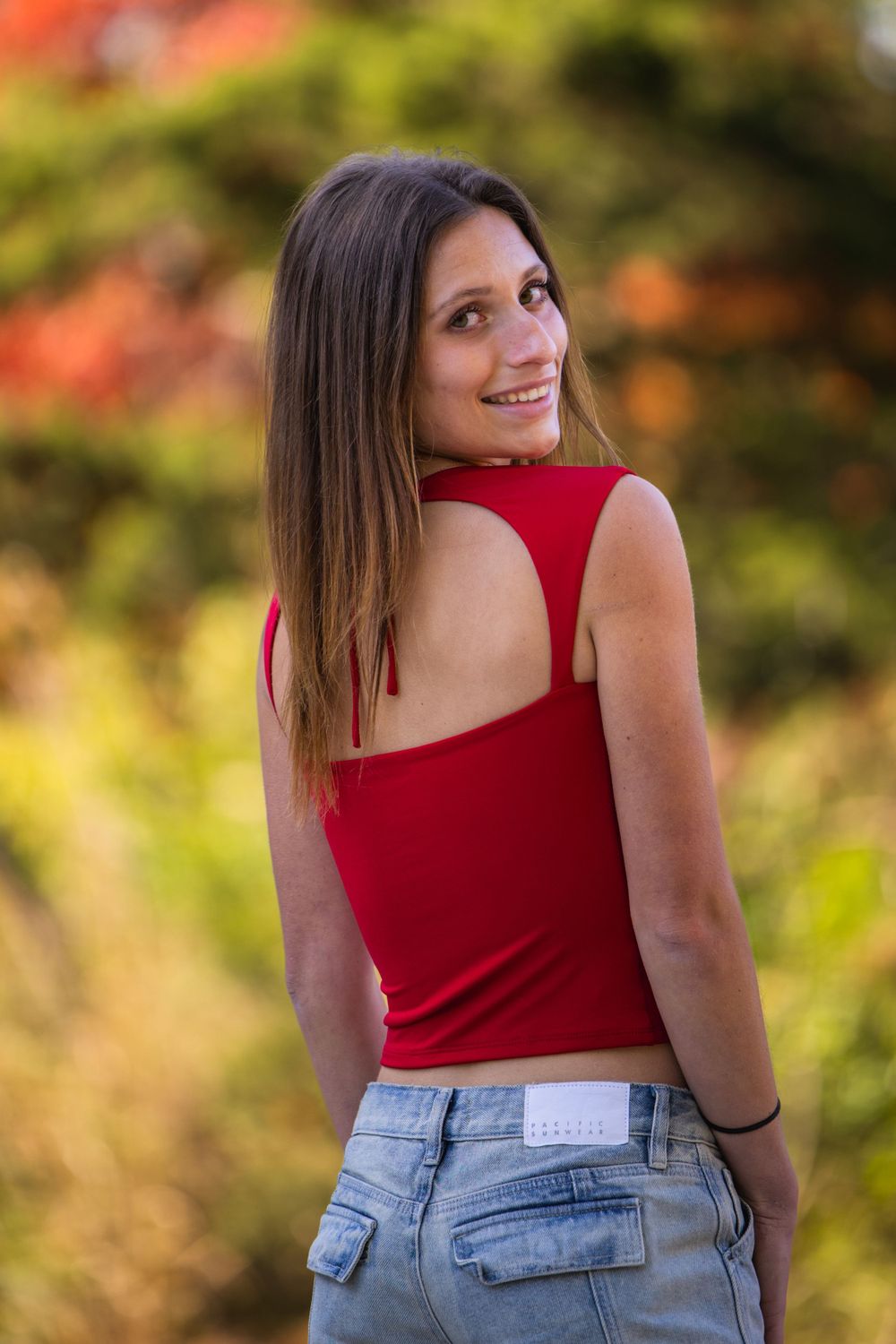 Senior girl in tank top among fall leaves, Faust Park fall senior photos St. Louis