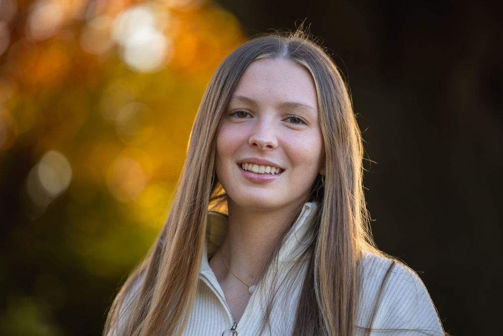 Senior girl in sweater among fall leaves, Faust Park fall senior photos St. Louis