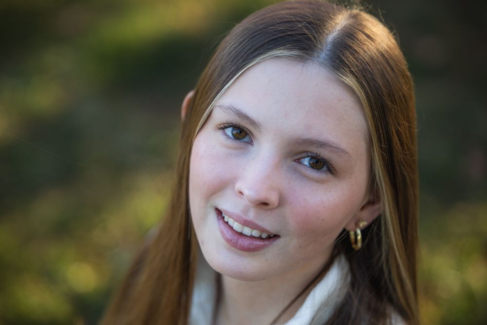Senior girl in sweater among fall leaves, Faust Park fall senior photos St. Louis