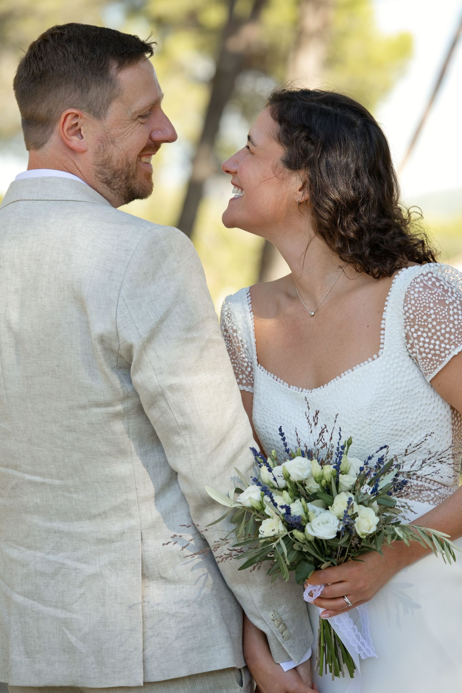Augustine et Ugo rient face à face, le bouquet de la mariée au premier plan.