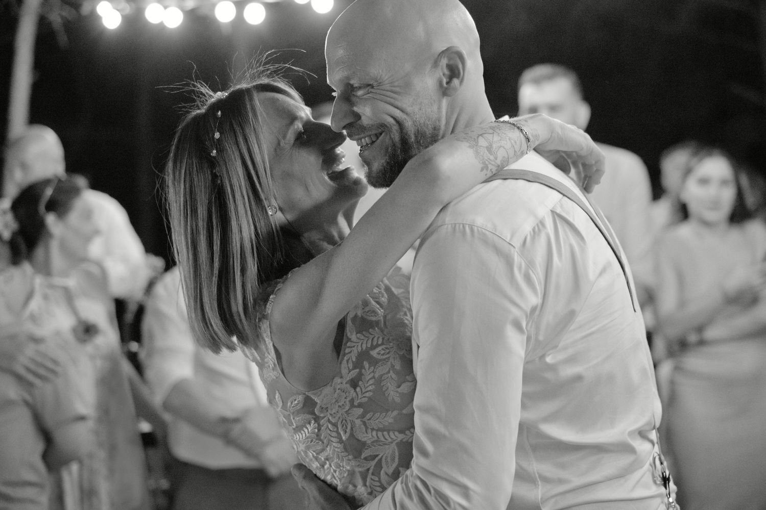 Delphine et Christophe se sourient pendant leur danse de mariage, en noir et blanc.