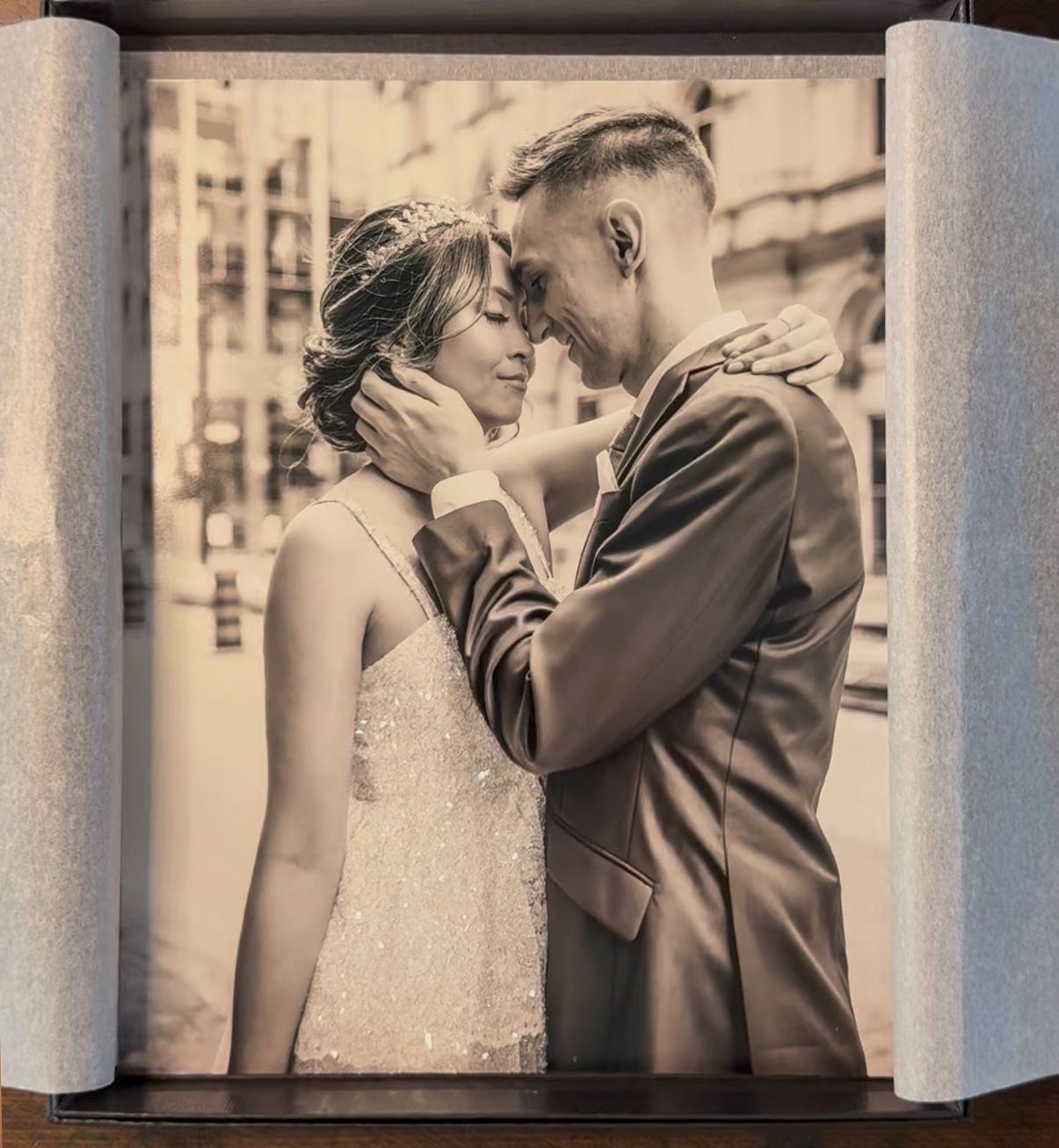 Black and white photo of a bride in a sparkling lehenga and groom in a suit posing in an elegant venue.