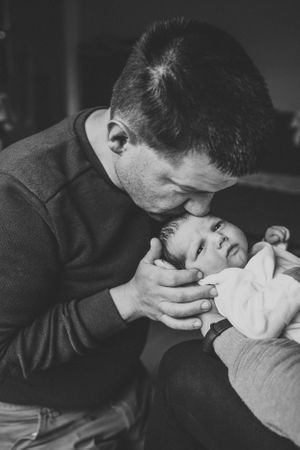 Intimate black and white portrait of nurturing moment with infant.