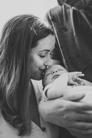 Intimate black and white portrait of mother and baby sharing a tender moment.