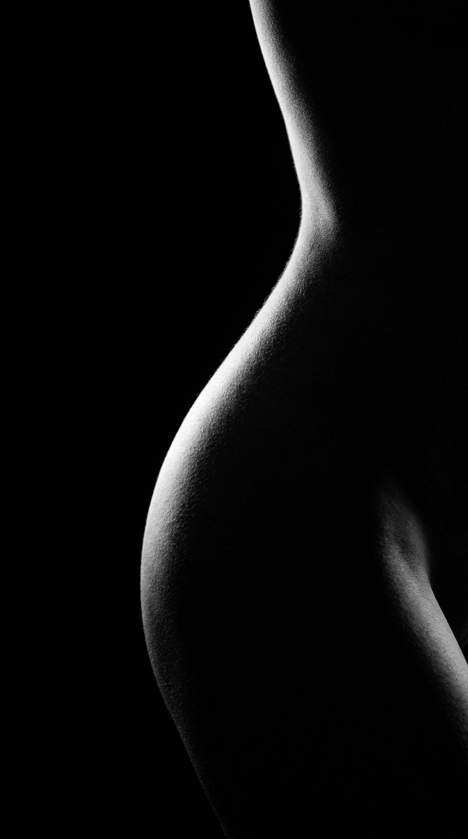 Black and white artistic nude silhouette of pregnant woman's curves.