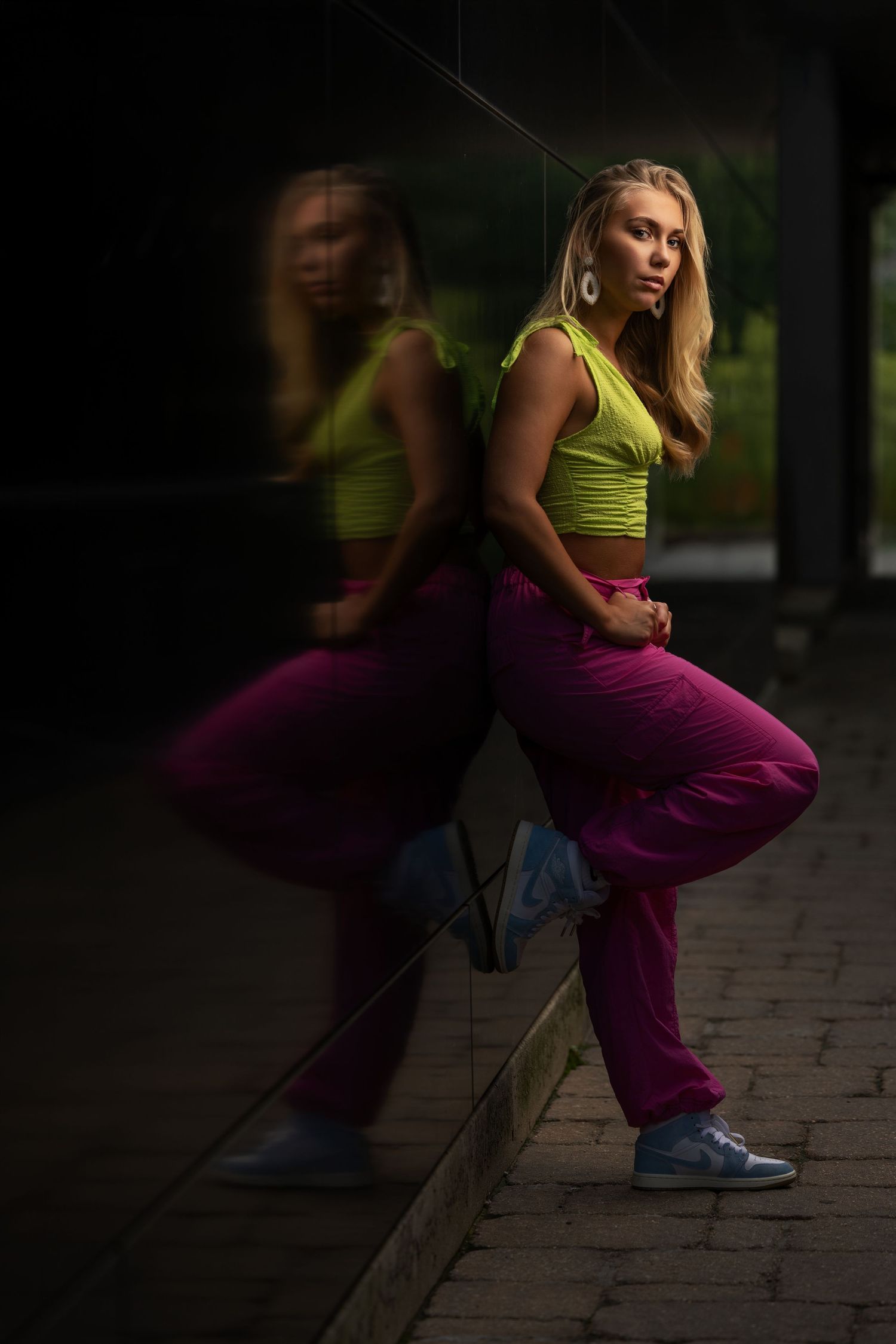 Creative senior portrait with colorful styling and dramatic lighting