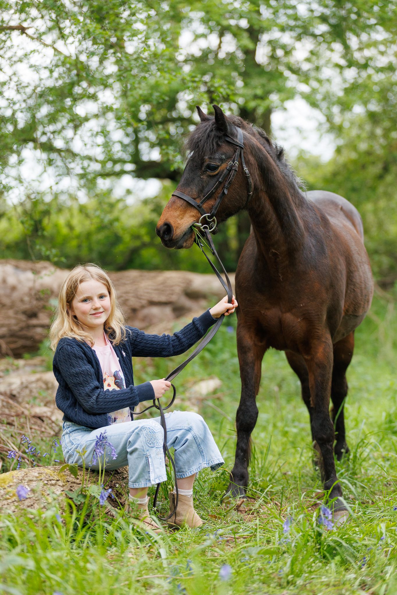 A smiling couple stands with a black and white horse and small dog in front of a white van on a farm.