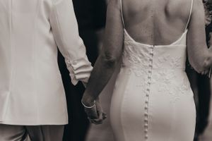 Close-up details of white wedding dress buttons and fabric texture.