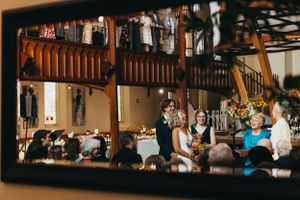 Wedding celebration in a historic church venue with guests on balcony overlooking dance floor.
