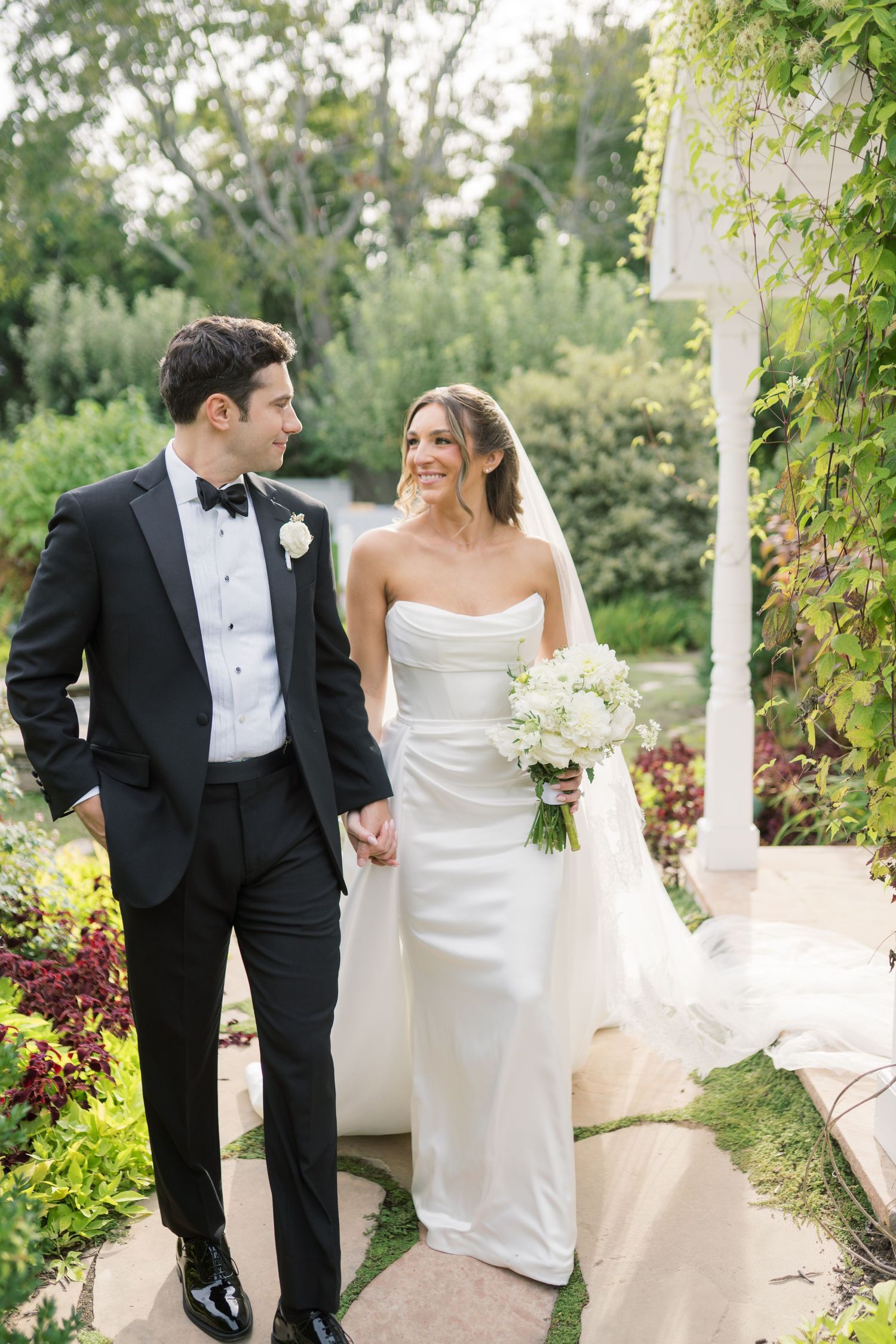 Beautiful garden setting with pink roses and gravel pathways at an elegant outdoor venue.