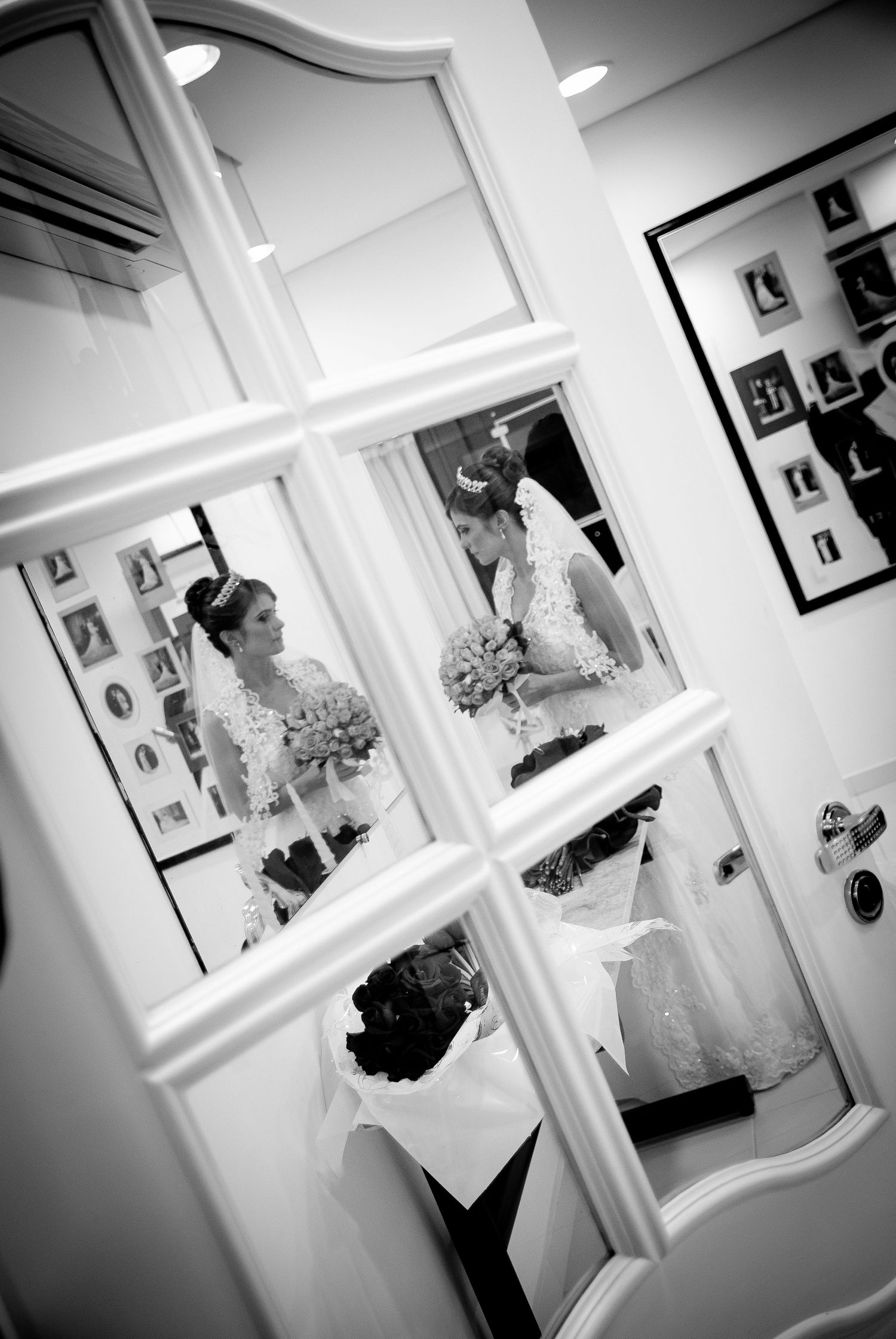 Bride's reflection captured multiple times in a white framed mirror during wedding preparations.