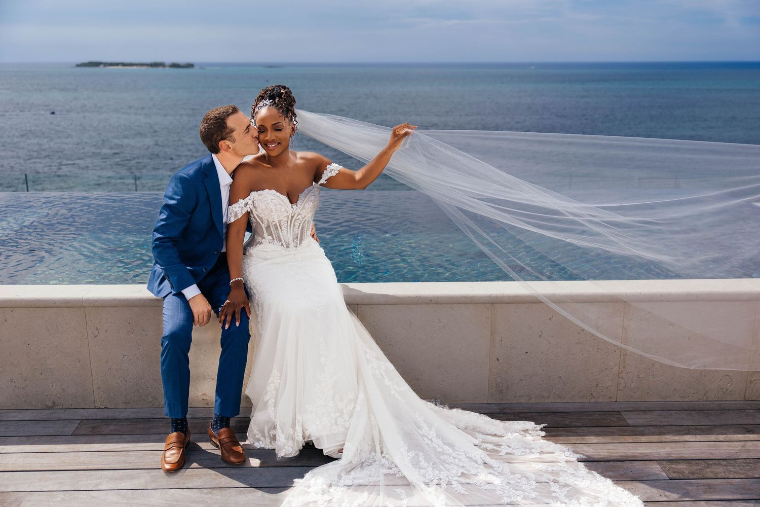 Romantic outdoor wedding ceremony with palm trees and flowing white veil.