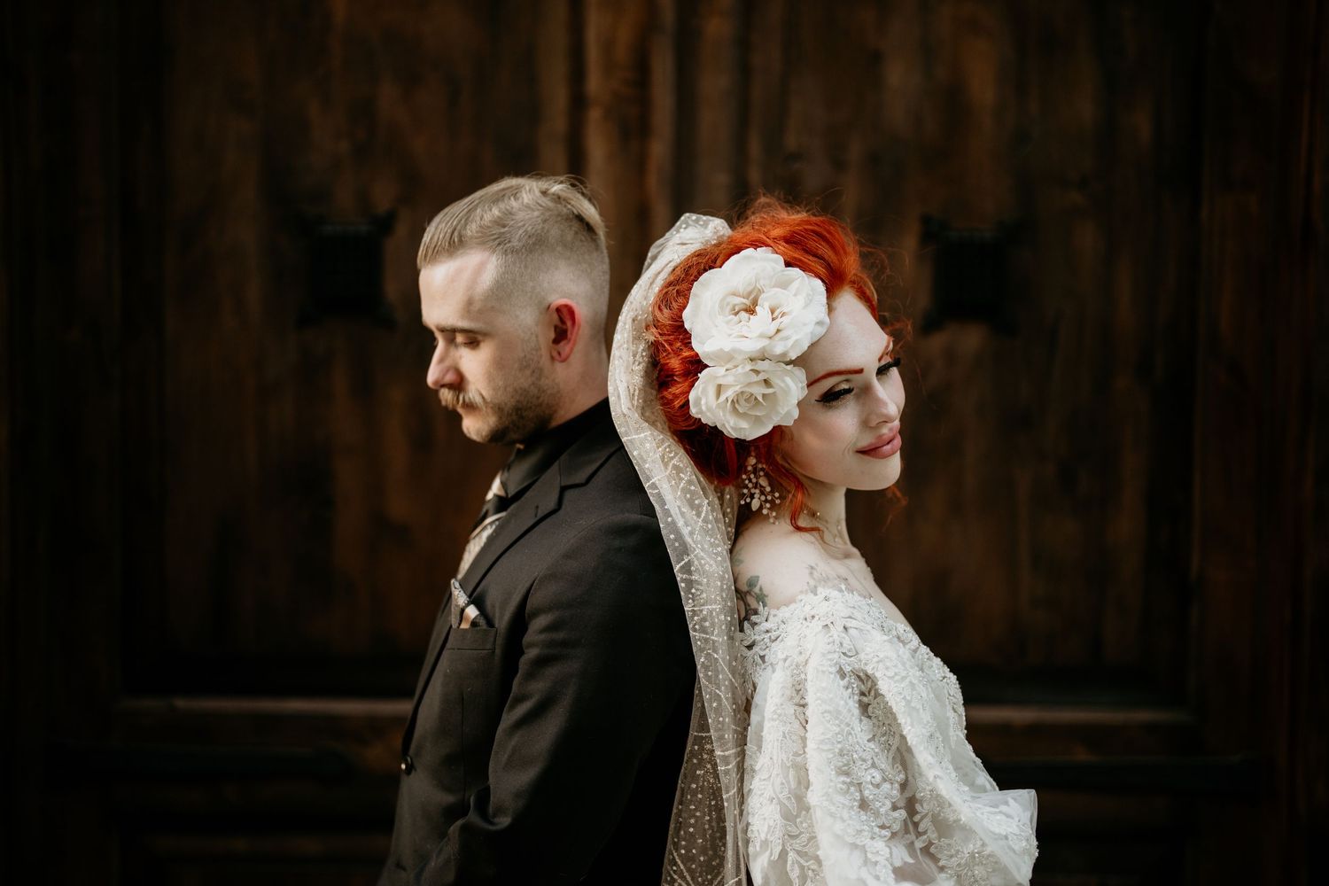 Red headed bride and groom leaning against each other in their wedding attire near Olympia, Washington