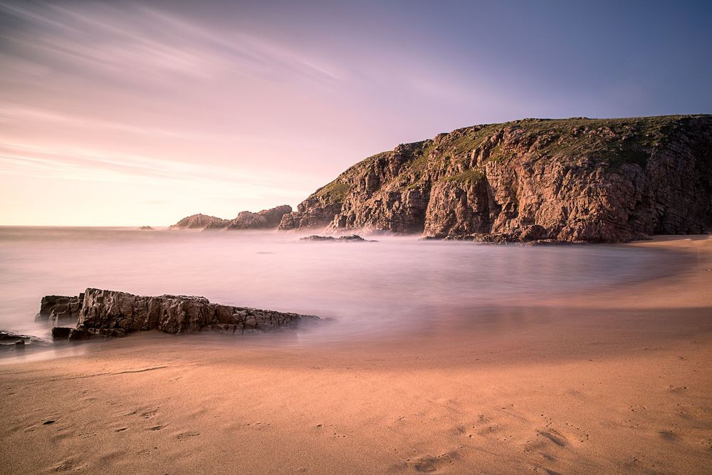 Spiaggia e scogliera di Murder Hole Beach con calda luce dorata