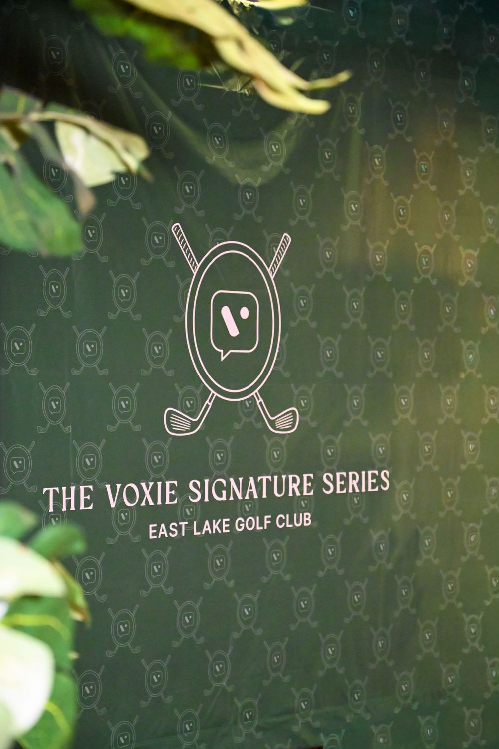 Green backdrop displaying The Voxie Signature Series logo and East Lake Golf Club text with crossed golf clubs emblem.
