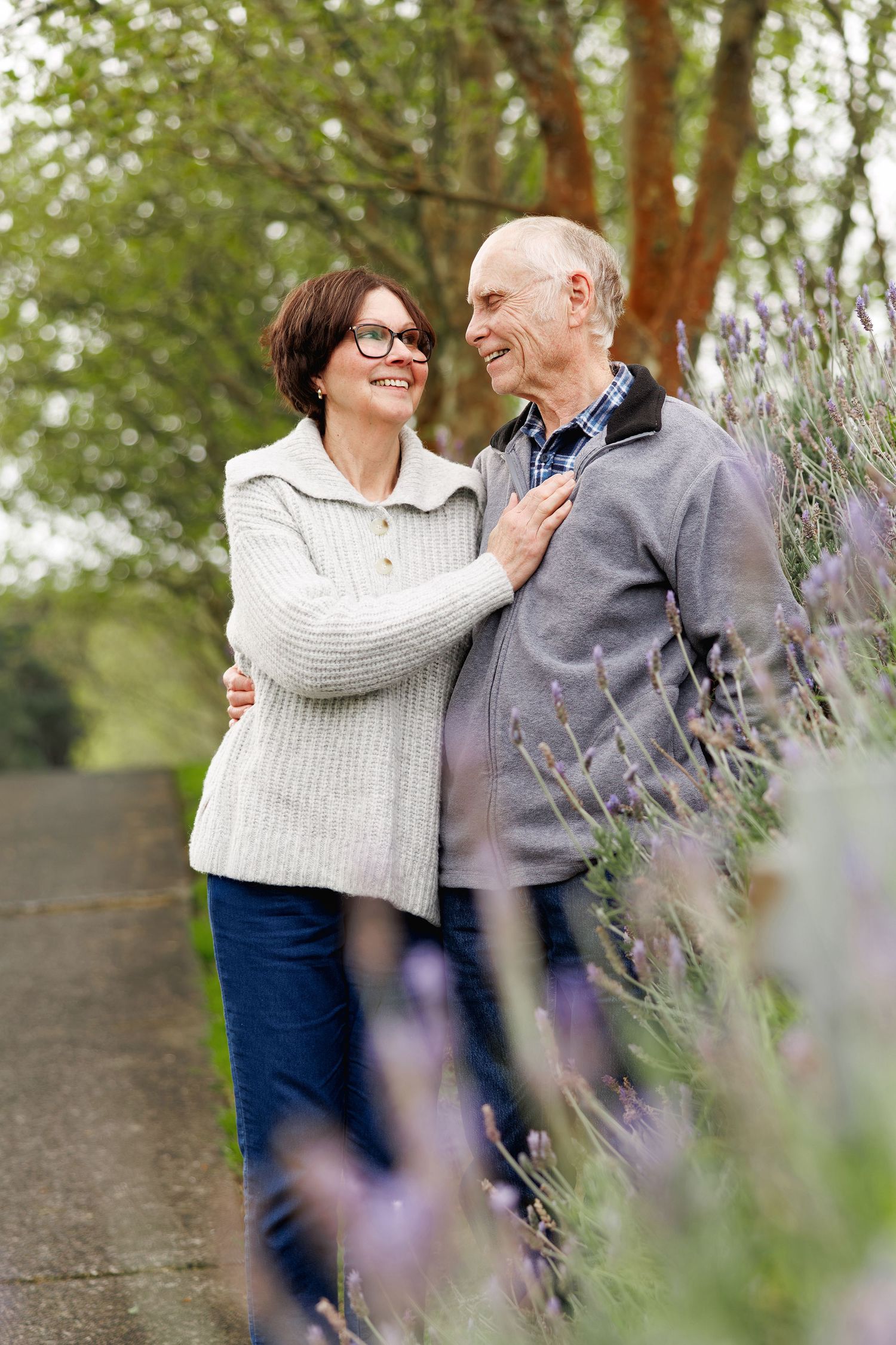 Couple embracing and laughing among vibrant lavender in Auckland