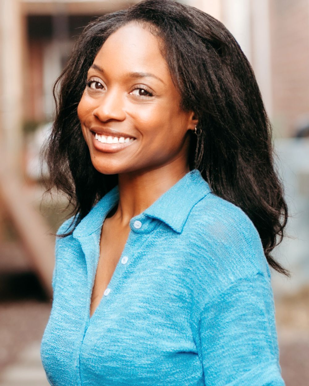 Commercial portrait of Genesis Dudley smiling in a blue blouse.