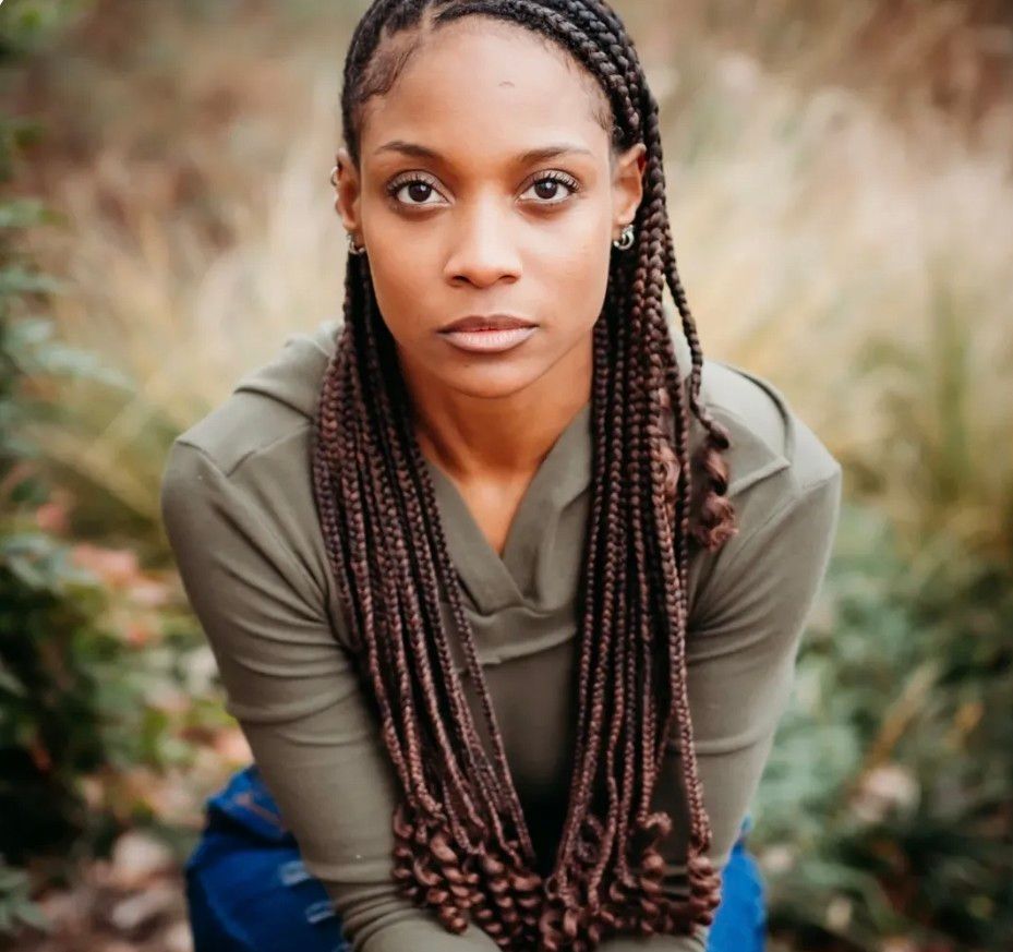 Headshot of Genesis Dudley with braided hair.