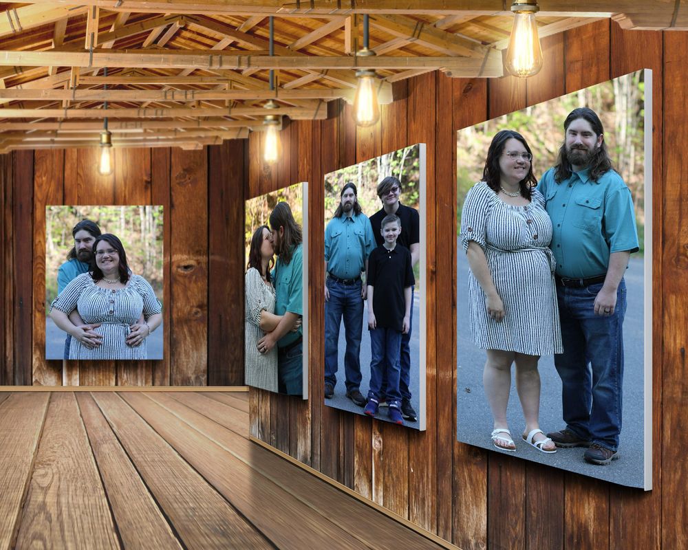 Family maternity photo display on rustic wood wall with warm Edison bulb lighting in a barn-style gallery setting.