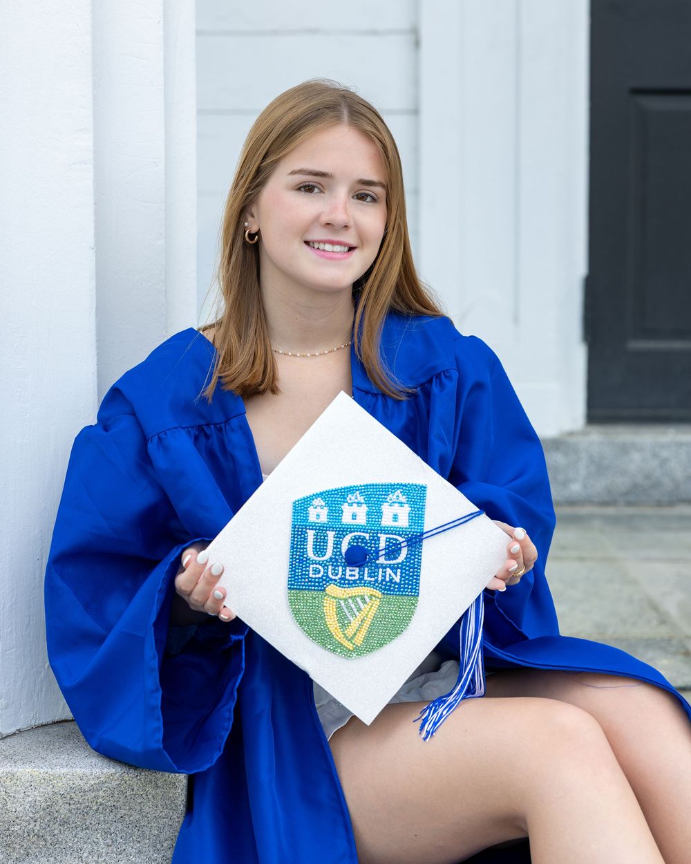 Lincoln Sudbury graduate hold her decorated mortar boards during cap & gown senior portrait. Weston High, Wayland, Concord Carlisle