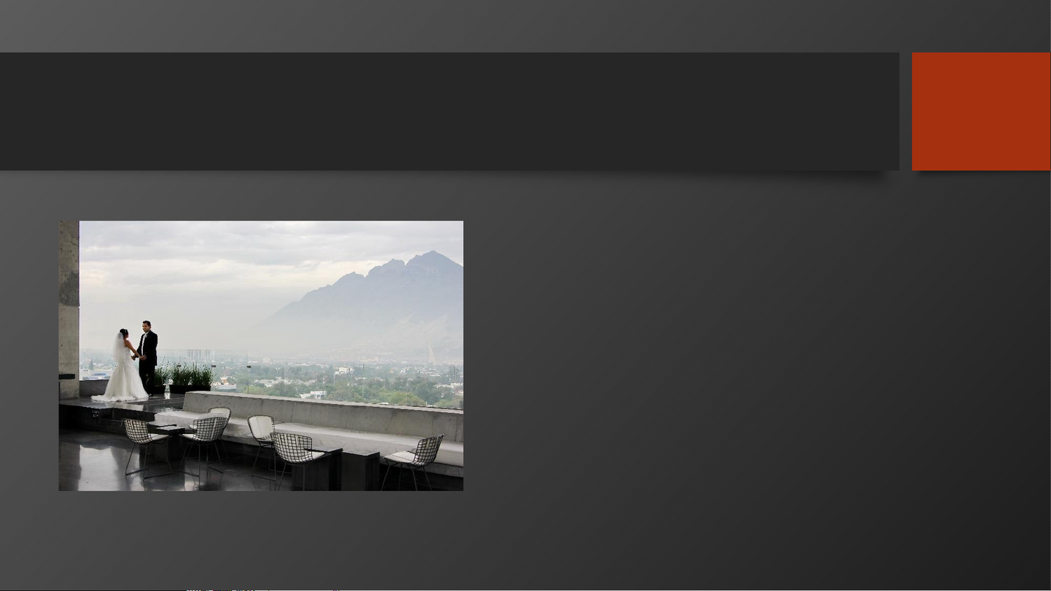 A bride and groom stand on a rooftop terrace with stunning mountain views and city skyline in the background.