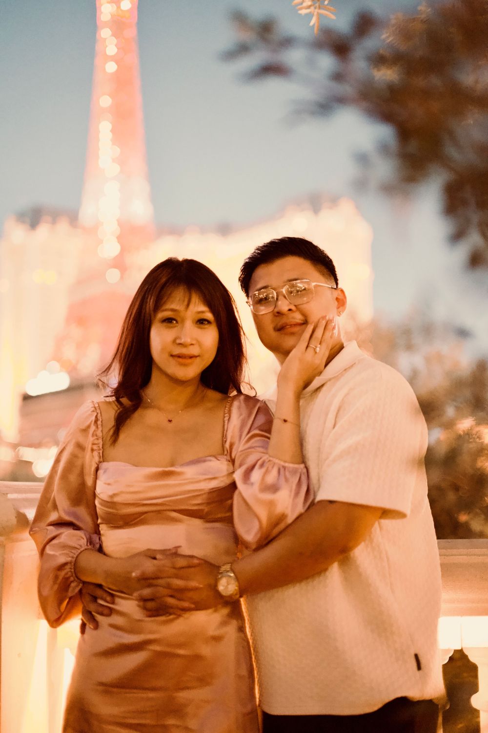 Happy Asian couple embracing near the Eiffel Tower replica on the Las Vegas Strip.