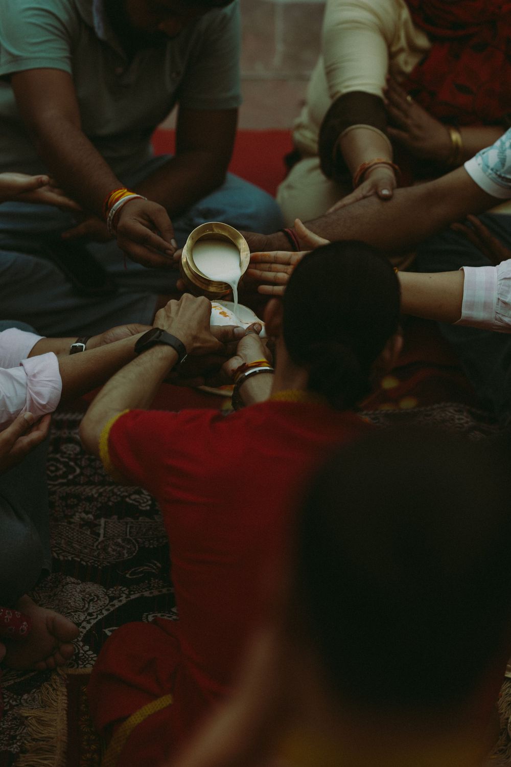 Group of people sharing milk during a traditional Hindu religious ceremony in India.